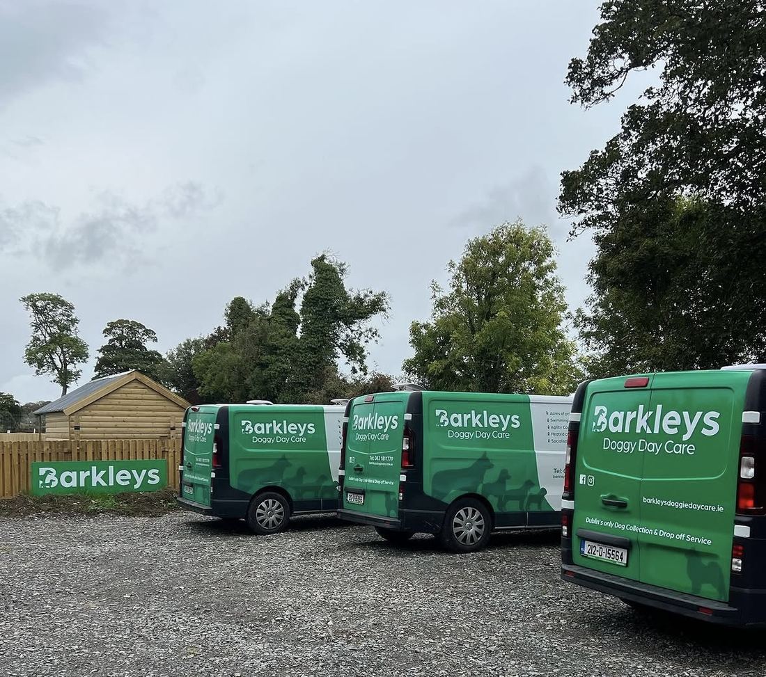 Three green Barkleys Doggy Buses parked in the yard at the farm